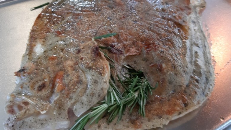 Whole fish, © Reef & Beef Baked fish with rosemary on a tray.