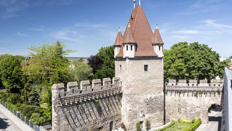 Private museum "Firearms past and present" in the Reckturm, © Wiener Alpen, Foto: Franz Zwickl Rectangular tower with red roof and stone wall, surrounded by trees and roads.