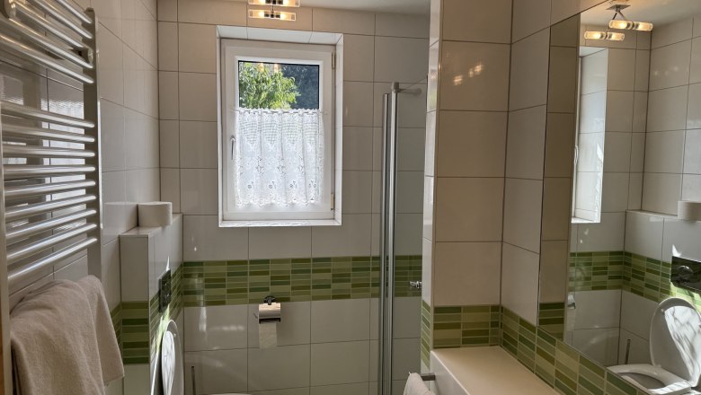 Hotel Zur Alten Schule, © Viregro Capital Gmbh Modern bathroom with green tiles, shower, WC and washbasin.