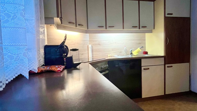 Heidi's Place_Kitchen, © Wiener Alpen Kitchen with dark worktop, light-colored cupboards and wooden ceiling.