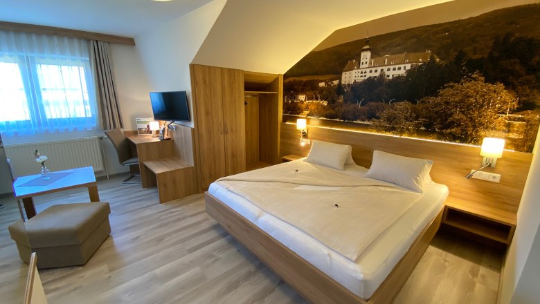 Double room summer, © Privatzimmer Leeb Modern hotel room with double bed, desk, TV and large mural.