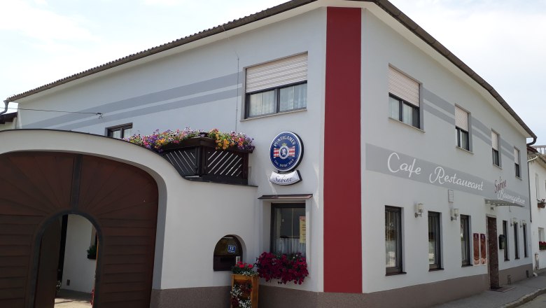 Café Restaurant Sabine, © Sabine Schneeweis Exterior view of Café Sabine with wooden gate, white and red façade and the inscription "Café-Restaurant".