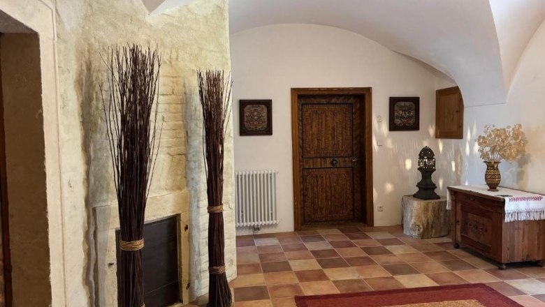 Entrance area, © Andrea Schubert Rustic entrance area with wooden door, decorations and tiled floor.