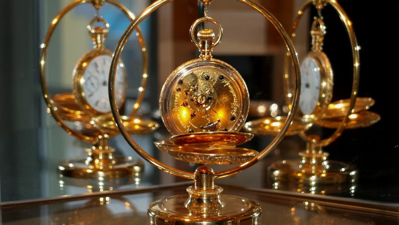 Karlstein Watch and Timekeeping Museum, © Uhrenmuseum Karlstein Golden pocket watch in a decorative stand, reflected in a mirror.