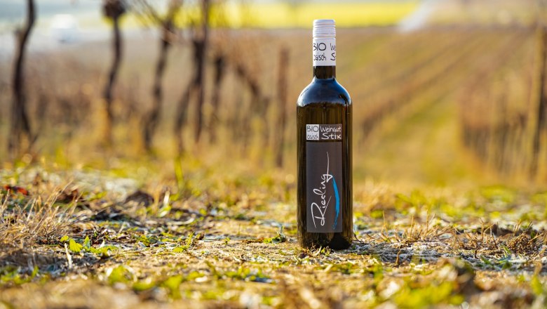 Organic winery Stix, © Weingut Stix A bottle of organic wine from the Stix winery stands in a vineyard.