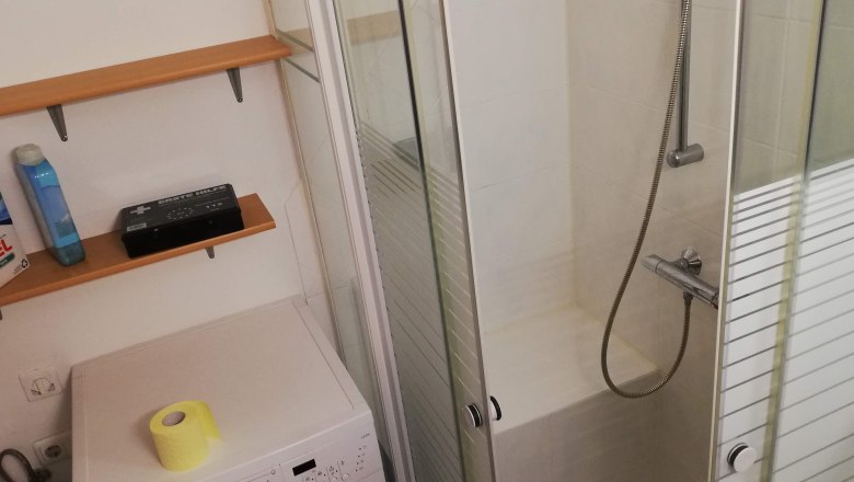 Bathroom, © Günter Lammer Bathroom with shower, washing machine and shelves.