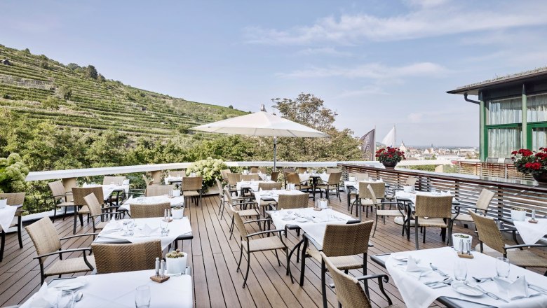 Restaurant Terrace, © Steigenberger Hotel and Spa, Gregor Titze Restaurant terrace with covered tables and views of the vineyards.