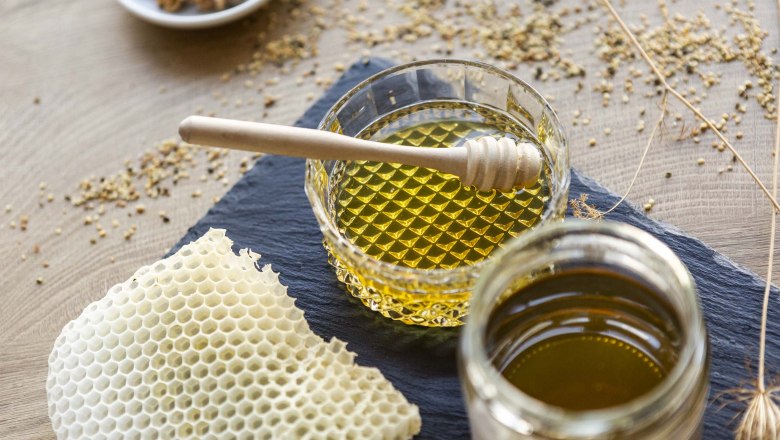 Honey, © Weinviertel Tourismus / Astrid Bartl Honey in glass jars with honey spoons and honeycombs on a table.