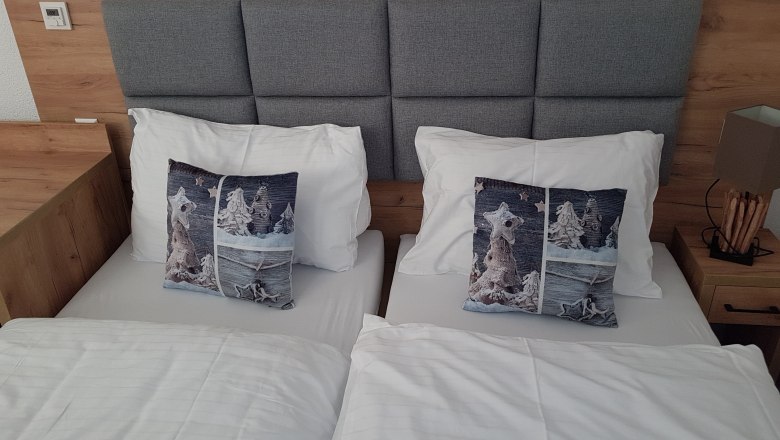 Double room, © Konrad Brandl Double room with two single beds, gray headboard, gray pillows and white bed linen
