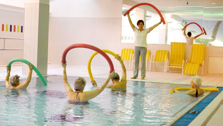 Indoor swimming pool, © Residenz Senior citizens group doing water aerobics in the indoor pool with swimming noodles.