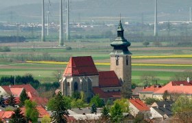 Church Pillichsdorf, © Thomas Falch Church in Pillichsdorf with surrounding houses and wind turbines in the background.