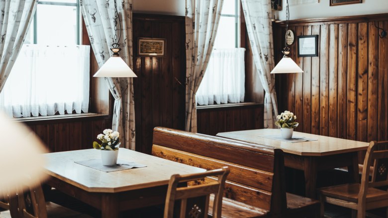 Convivial dining room and large ballroom, © Niederösterreich Werbung/David Schreiber Cozy, rustic restaurant with wooden furniture and flowers on the tables.