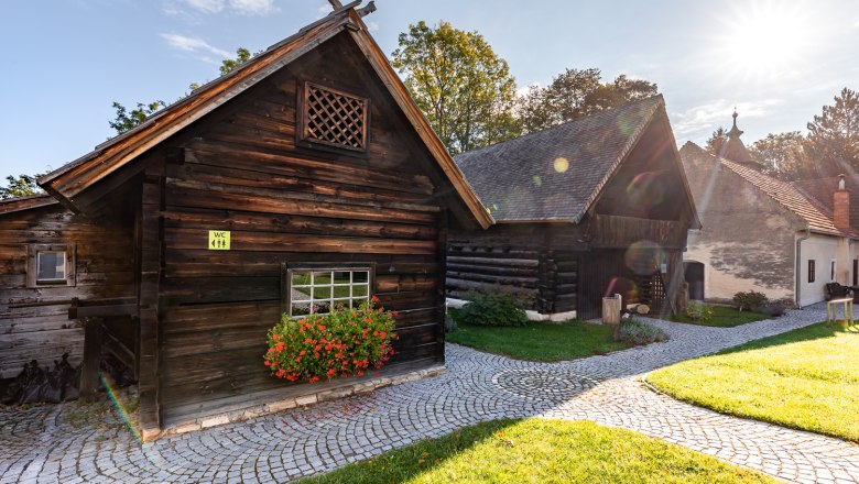 Krumbach Museum Village, © Wiener Alpen, Christian Kremsl Traditional wooden houses in the Krumbach museum village in the sunshine.