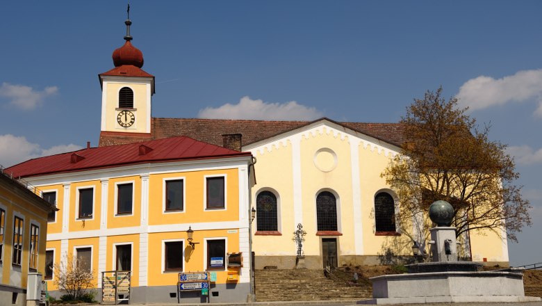 Main square - church, © Gerhard Wanko Church with yellow façade and tower with red roof on a main square.