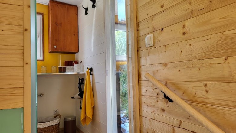 Staircase to the bathroom, © Villa to go Interior view of a bathroom with wood paneling and yellow accents.