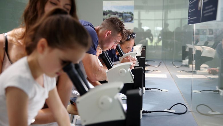 Microscopy station, © © Waldviertel Tourismus, weinfranz People look at objects through microscopes in an exhibition room.