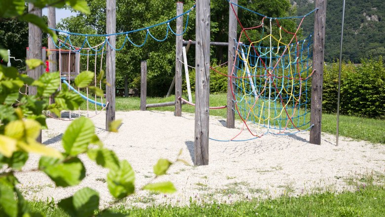 Adventure playground in Joching, © Donau NÖ Tourismus_Barbara Elser An adventure playground with climbing ropes and wooden poles, surrounded by green nature.