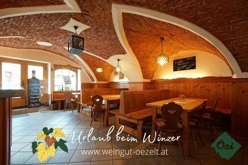 Özi's Heurigenlokal, © DM Interior view of a cozy wine tavern with vaulted brick ceiling and wooden furniture.