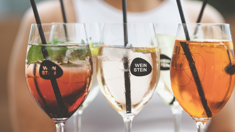 WineStone in a glass, © Michael Reidinger Close-up of wine glasses with various drinks and straws.