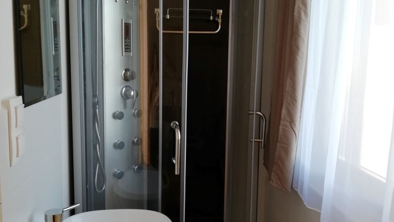 Apartment-bathroom, © Familie Weibels Modern bathroom with shower cubicle and washbasin.