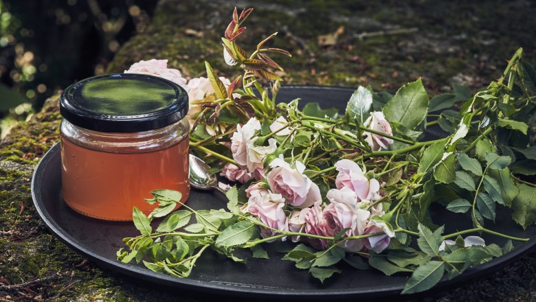 Special: Rose petal jelly, © Niederösterreich Werbung/Andreas Hofer A glass of rose petal jelly next to fresh roses on a tray outside.