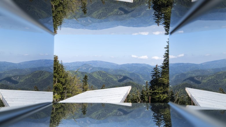 View through the viewer, © Wiener Alpen, Franz Zwickl Reflection of a mountain panorama with trees and blue sky.