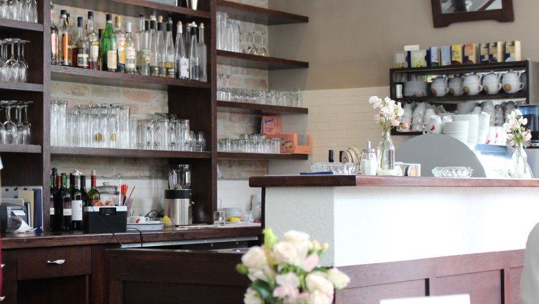 Bar in the Weydner Wirtshaus, © Weydner Wirtshaus Interior view of a bar with shelves full of glasses and bottles, flowers on the counter.