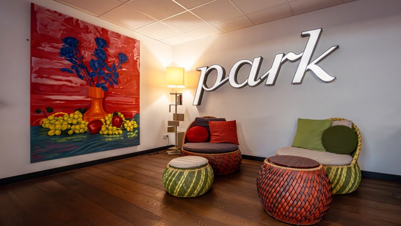 At the Park Hotel, © Niederösterreich Werbung / Maximilian Pawlikowsky A stylish hotel lounge area with colorful furniture and a large painting on the wall.