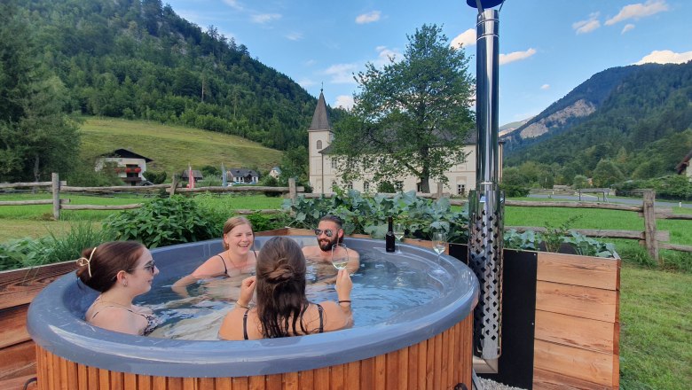 Glamping Wilderness Center Nasswald, © Jonathan Clark Group of people in a hot tub in a rural setting.