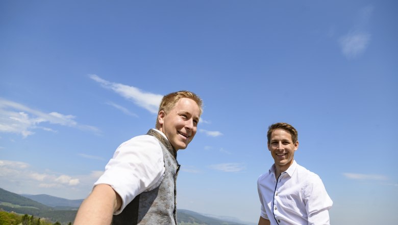 Simon brothers in their orchard, © Thomas Gobauer-Photography Two men in traditional dress smile at the camera in an orchard