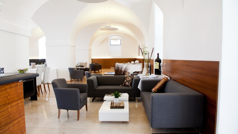 Bar-Restaurant, © Hotel Altes Kloster GmbH Elegant bar-restaurant with modern gray sofas and white walls.