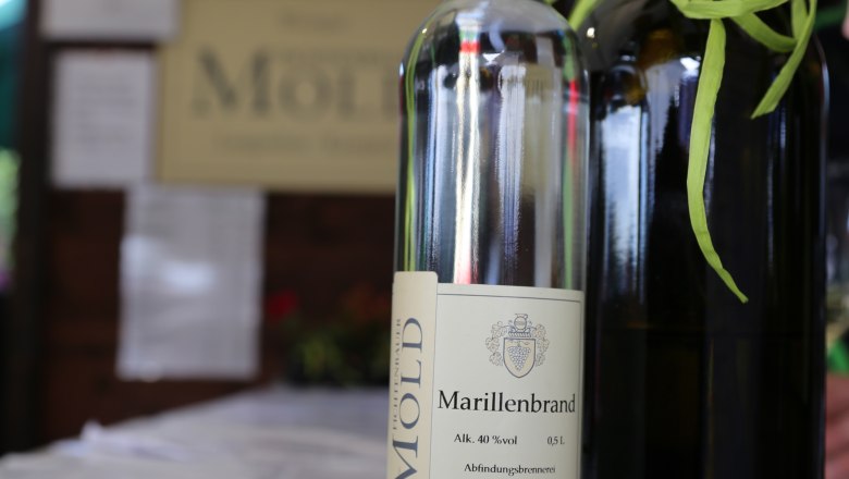 Winery Erwin & Christa Fichtenbauer-Mold, © Waldviertel Tourismus_Theresia Steinkellner Stand A bottle of apricot brandy from the Fichtenbauer-Mold winery on a table.