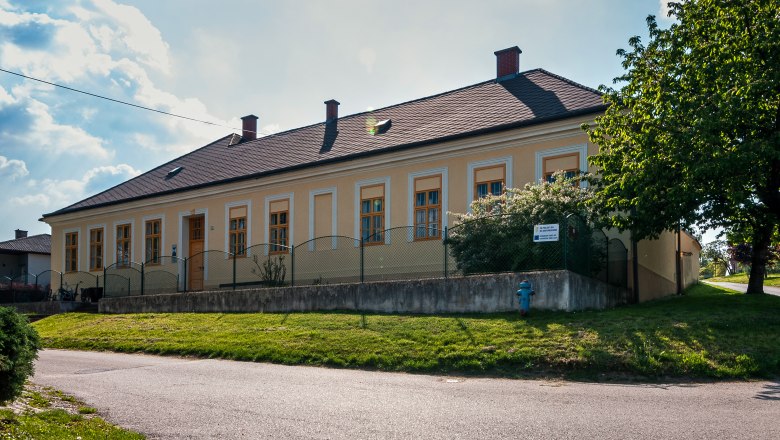 Museum of local history, © Marktgemeinde Jedenspeigen A yellow building with several windows and a fence in front of it, surrounded by trees and a lawn.