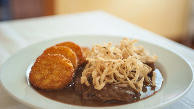 Bayer Inn, © Clara Körner A plate with hash browns, gravy and fried onions.