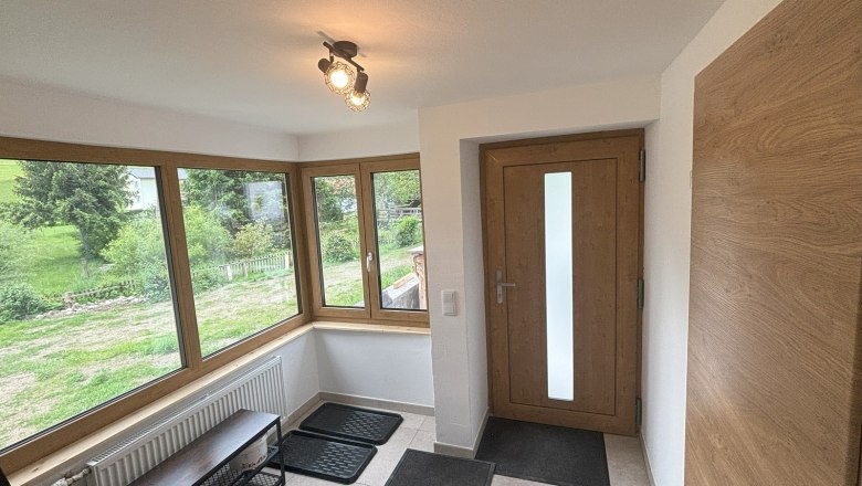 Anteroom, © Michael Hofer Bright entrance hall with large windows, wooden door and tiled floor.