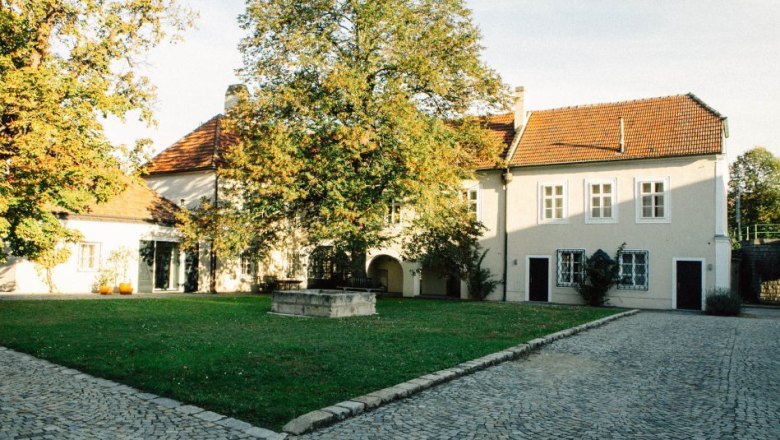 Inner courtyard of the Salomon Undhof, © Salomon Undhof Inner courtyard of a historic building with paved path, lawn and trees.