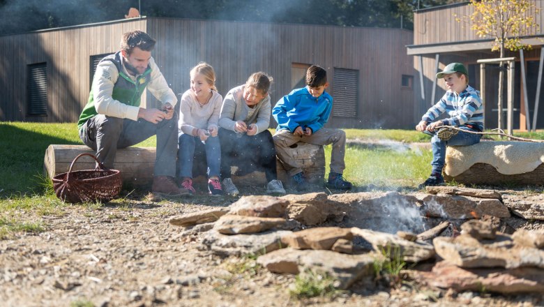 Campfire at the Wildcat Camp, © Waldviertel Tourismus / Studio Kerschbaum Group of children and an adult around an outdoor campfire.