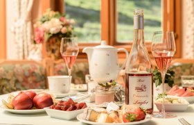 Breakfast at the Weinberghof, © Rita Newman Breakfast table with fruit and cheese and a bottle of Frizzante