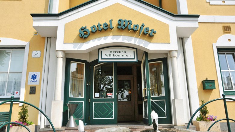 Hotel Restaurant Moser, © Hotel Moser Entrance to Hotel Moser with yellow façade and green doors.
