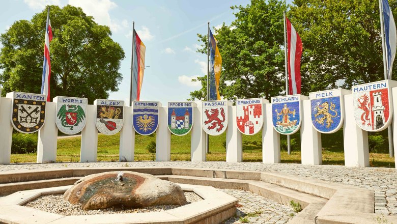 Nibelung Monument, © Klaus Engelmayer Nibelungen monument with coats of arms of various towns and flags in the background.
