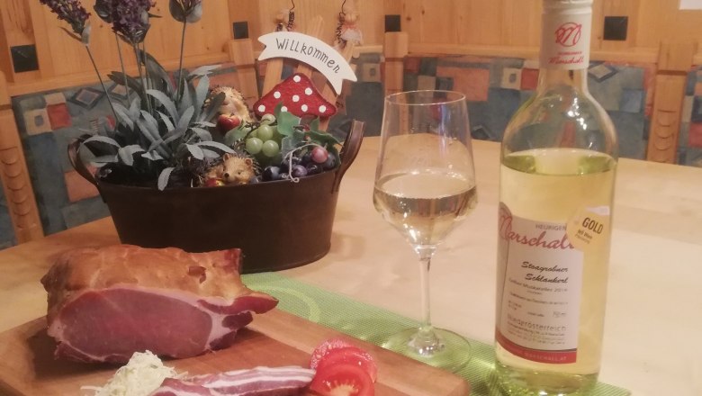 Wine taverns, © Heurigenhof Marschall A table with ham, wine and decoration.