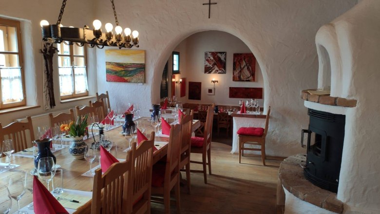 Tasting, © Bio-Weinbau Killmeyer Cozy room with table setting, wine glasses and fireplace.