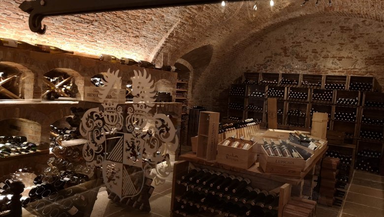 Wine cellar in Dürnstein Castle, © Johannes Christian Thiery Wine cellar with brick vaults and wine bottles on shelves.