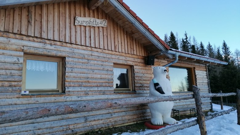 Sumpihittn #2, © Wiener Alpen Klikovics Wooden hut with polar bear figure and snow remains in the foreground.