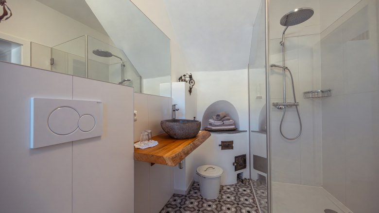Apartment house Leopold an der Ybbs, © Niederösterreich Werbung / Maximilian Pawlikowsky Modern bathroom with glass shower, stone washbasin and patterned floor.