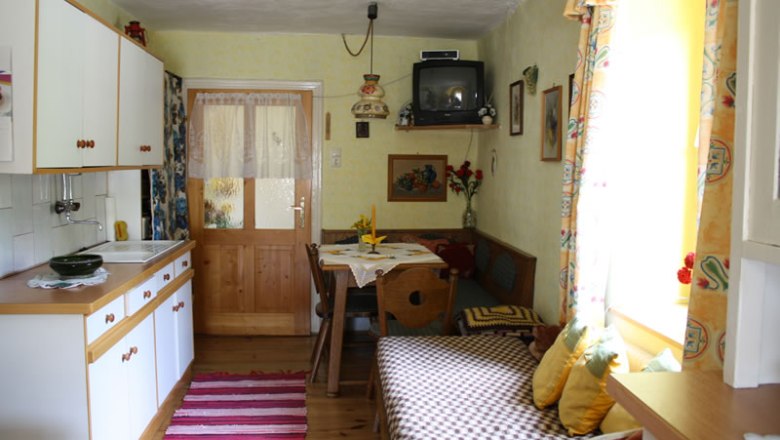 Kitchen in the vacation apartment, © Jamek Cozy kitchen in a vacation apartment with wooden furniture, small dining table and TV.