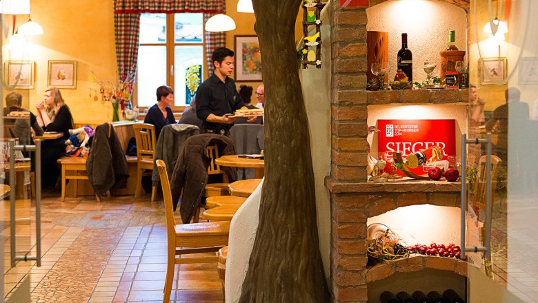 Interior view of the wine tavern, © Der Baumgartner Interior view of a wine tavern with tree decoration and wine rack.