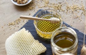 Honey, © Weinviertel Tourismus / Astrid Bartl Honey in glass jars with honey spoons and honeycombs on a table.