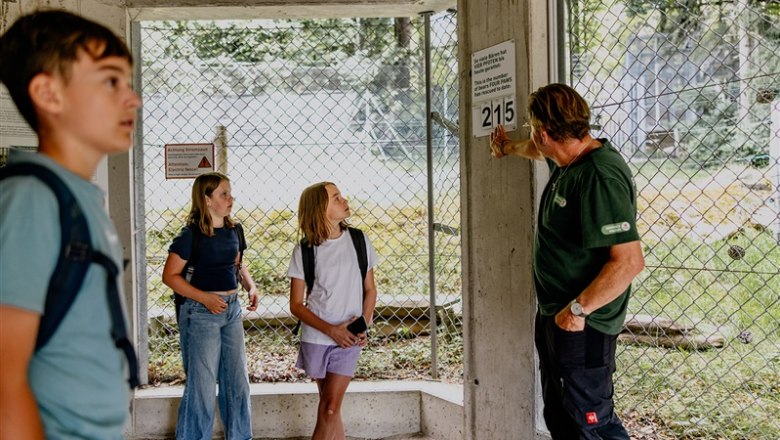 Arbesbach Bear Sanctuary, © Waldviertel Tourismus, Matthias Streibel A man shows three children a sign in an enclosure in the Arbesbach bear sanctuary.