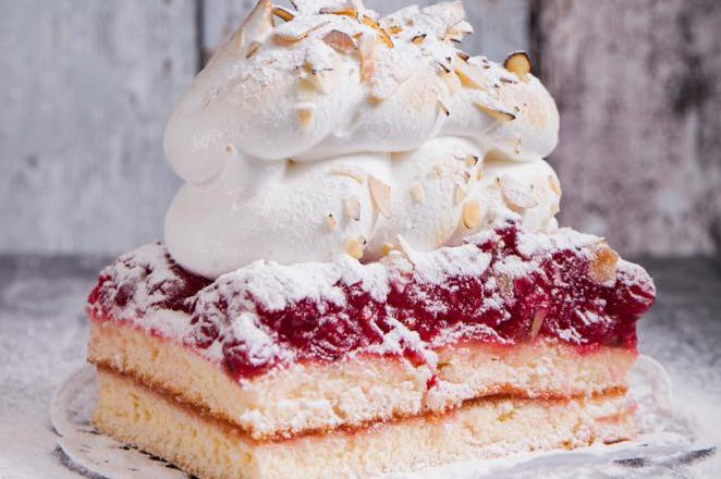 Pauntzen Bakery Traismauer, © Lukas Pauntzen A slice of cake topped with whipped cream and slivered almonds.